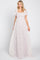 Woman wearing a light pink floral maxi dress with smocked bodice and flutter sleeves