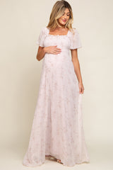 pregnant woman in light pink floral maternity maxi dress with smocked bodice and flutter sleeves