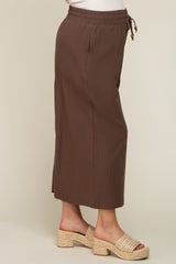 Woman wearing brown wide leg drawstring pants and woven platform sandals