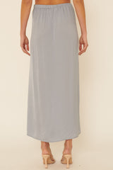 woman wearing a light grey maxi skirt with an elastic waistband, viewed from the back