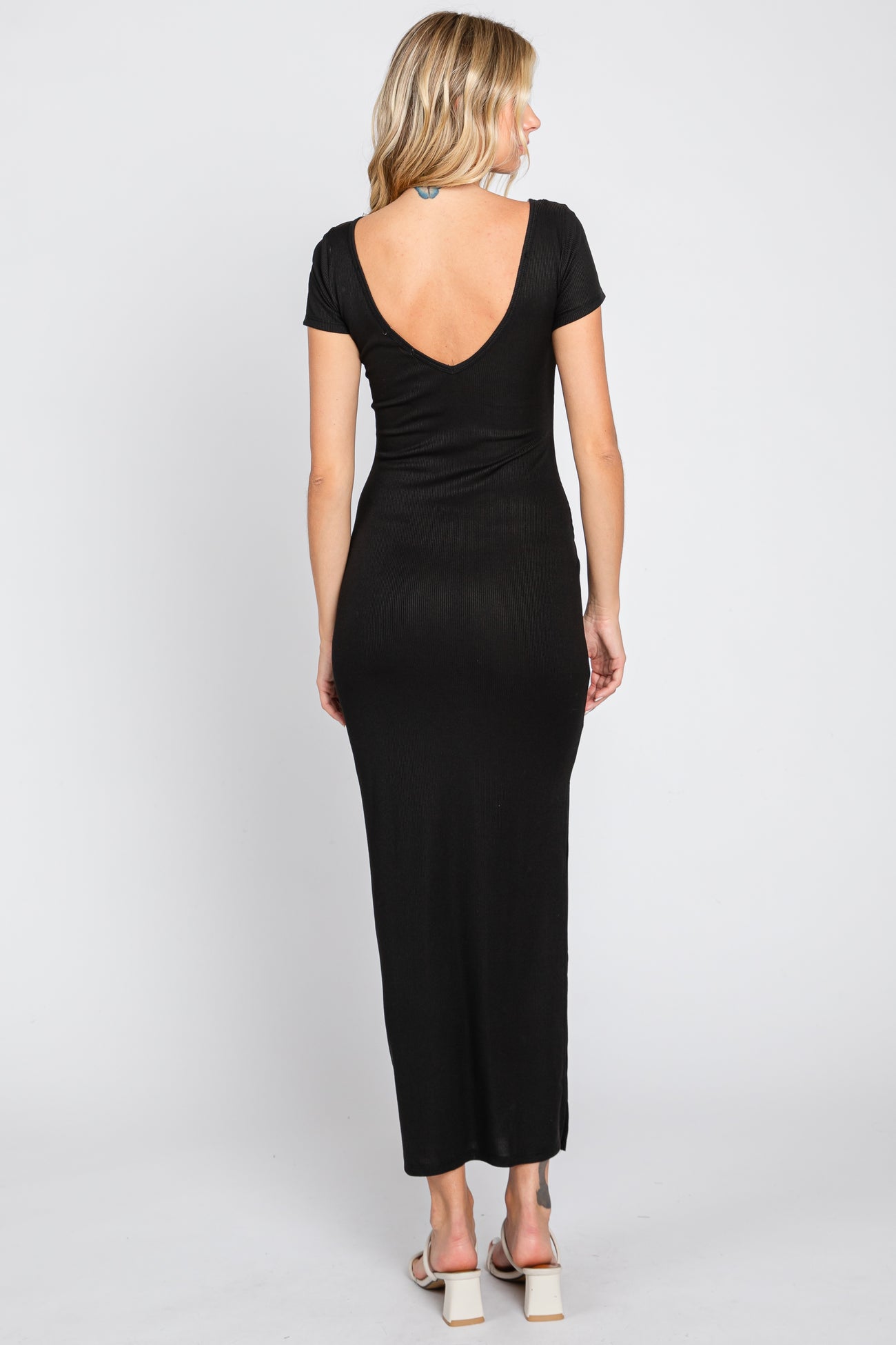 woman wearing a black ribbed maxi dress with a deep v-back and short sleeves