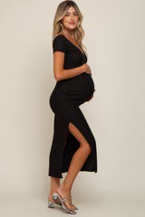 Pregnant woman in a black short sleeve maternity midi dress with a side slit and snakeskin heels