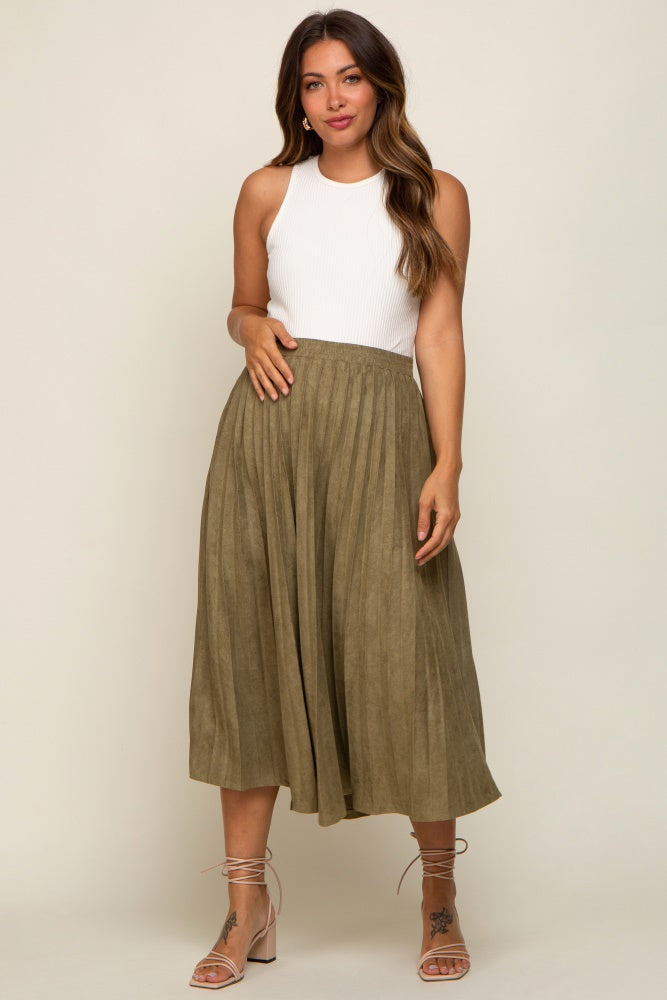 woman wearing white ribbed tank top and olive green pleated midi skirt with lace up heels