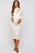woman wearing a cream ribbed maternity dress with cut-out details and holding her baby bump