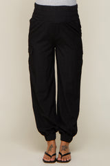woman wearing black maternity cargo pants with an elastic waistband and tapered ankle cuffs