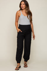 woman wearing a gray tank top and black maternity jogger pants with pockets
