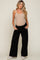 pregnant woman wearing a beige ribbed maternity tank top and black wide leg pants