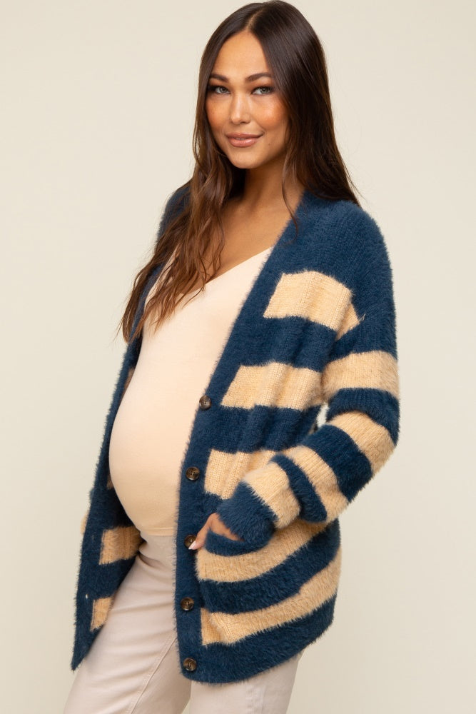 pregnant woman wearing a blue and tan striped fuzzy maternity cardigan over a beige top