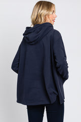 Back view of a woman wearing an oversized navy blue hooded sweatshirt with side slits