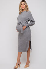 woman wearing a gray ribbed maternity dress with a tie waist and side slits, showcasing her baby bump