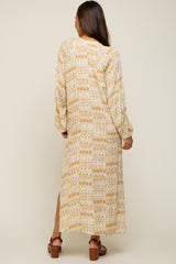 woman wearing a long sleeve beige and yellow patterned maternity dress with a side slit