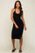 woman wearing a black ribbed midi halter dress with side slit and black slide sandals