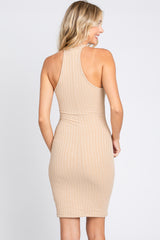 back view of a woman wearing a beige ribbed knit halter neck bodycon dress