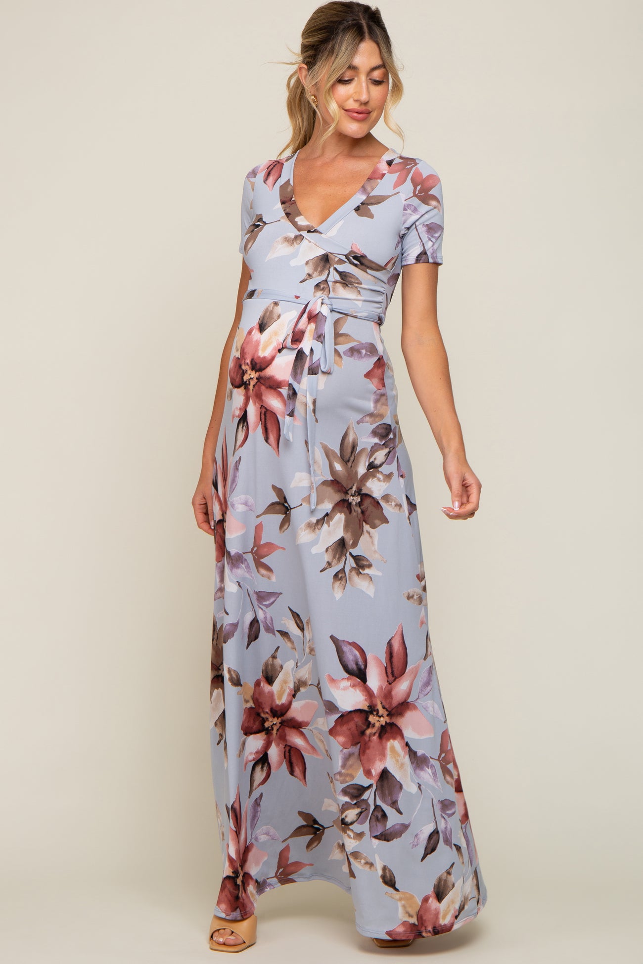 pregnant woman wearing light blue floral maternity maxi dress with short sleeves and waist tie