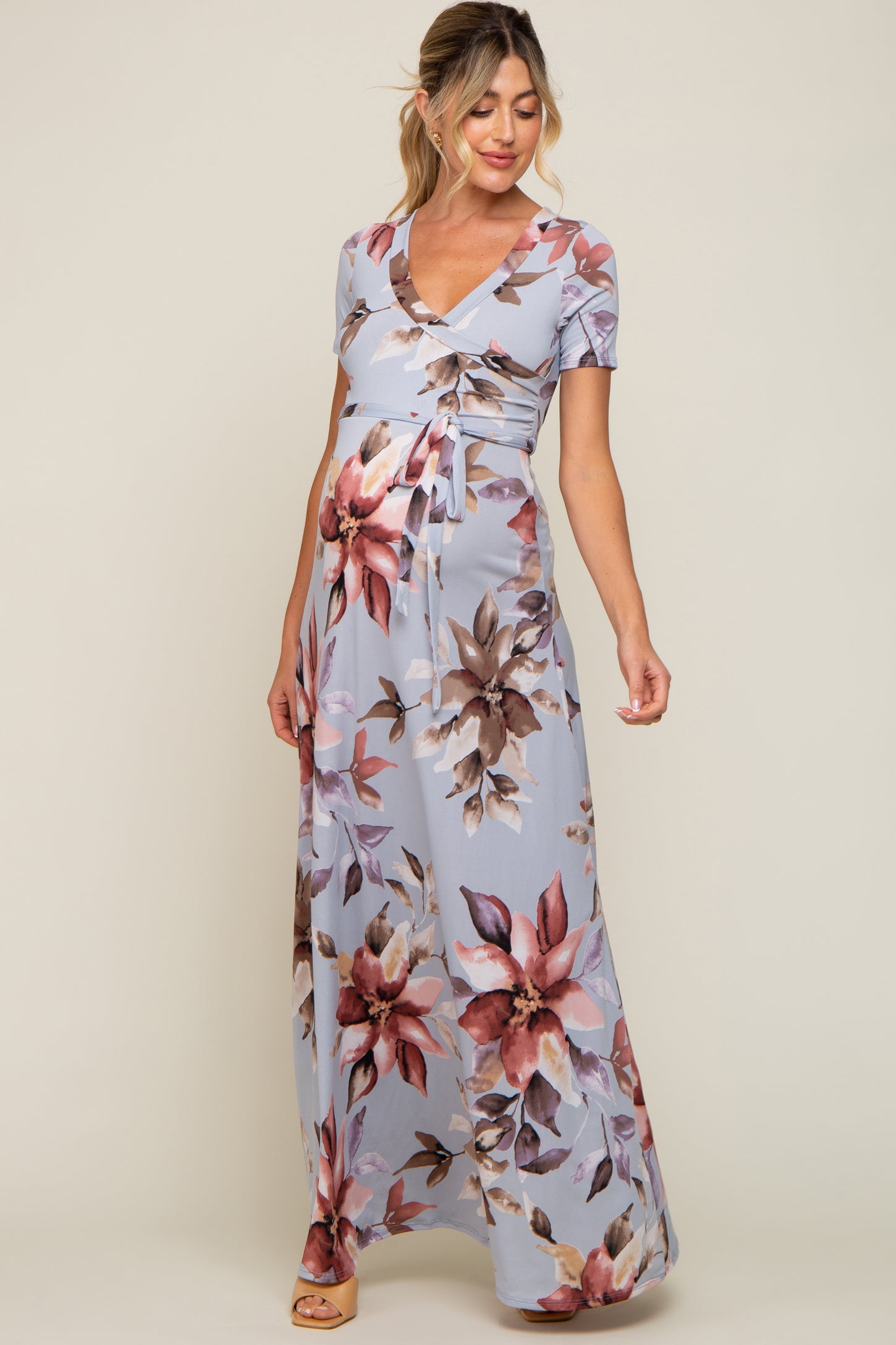 pregnant woman wearing light blue floral maternity maxi dress with short sleeves and waist tie