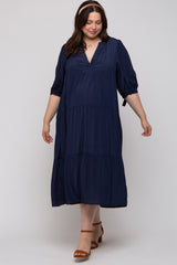woman wearing a navy blue tiered maternity dress with a deep v-neck and puff sleeves