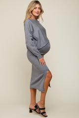 woman wearing a gray maternity dress with a side slit and a visible baby bump