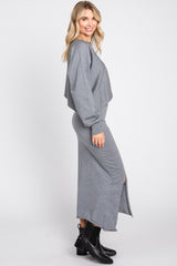 woman wearing a gray cropped sweater and matching maxi skirt with a side slit and black ankle boots
