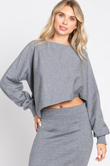 woman wearing a gray cropped sweatshirt with long sleeves and a matching ribbed skirt