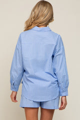 Back view of a woman wearing a blue and white striped long sleeve button down shirt and matching shorts