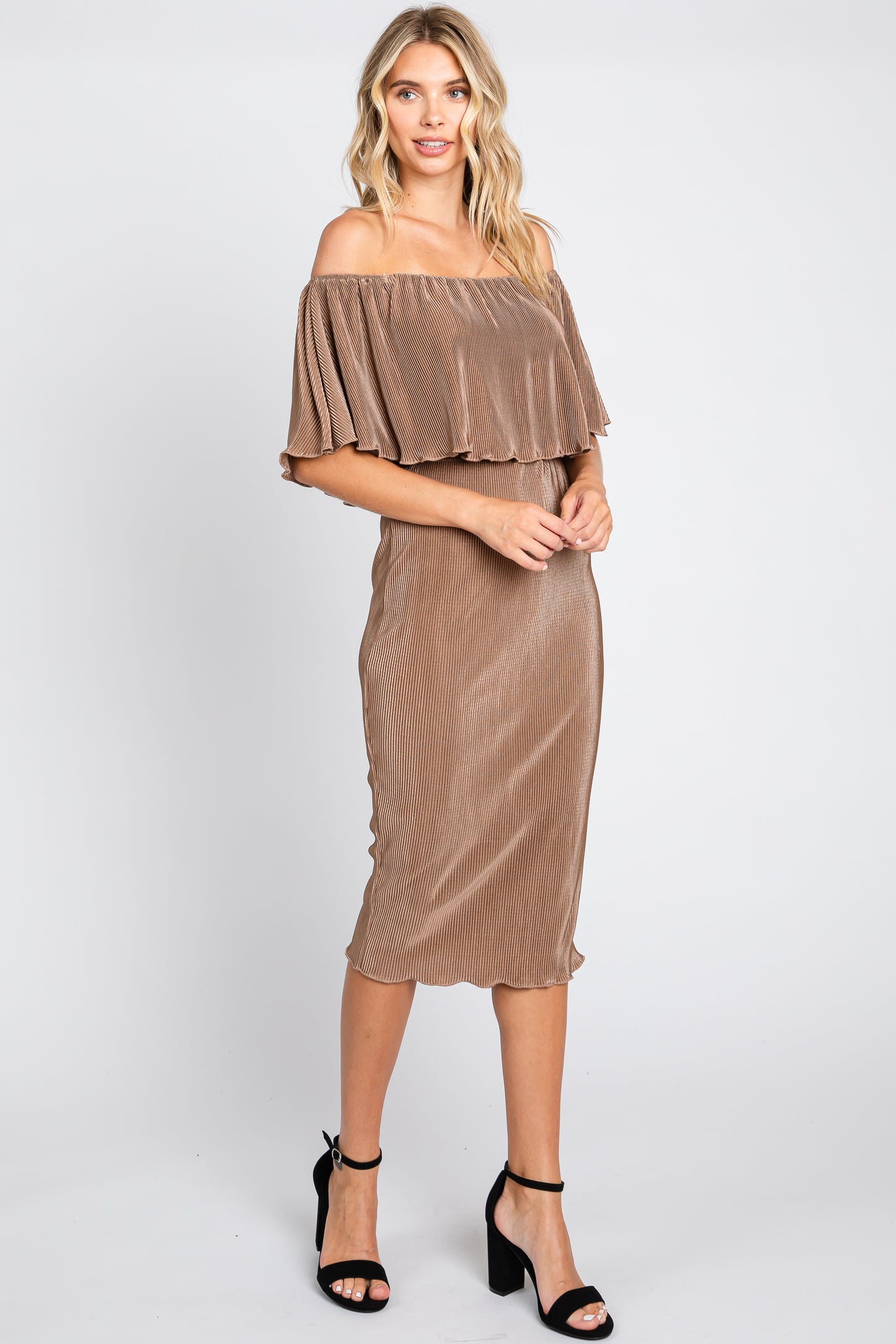 Woman wearing a bronze off-the-shoulder pleated midi dress and black high heel sandals