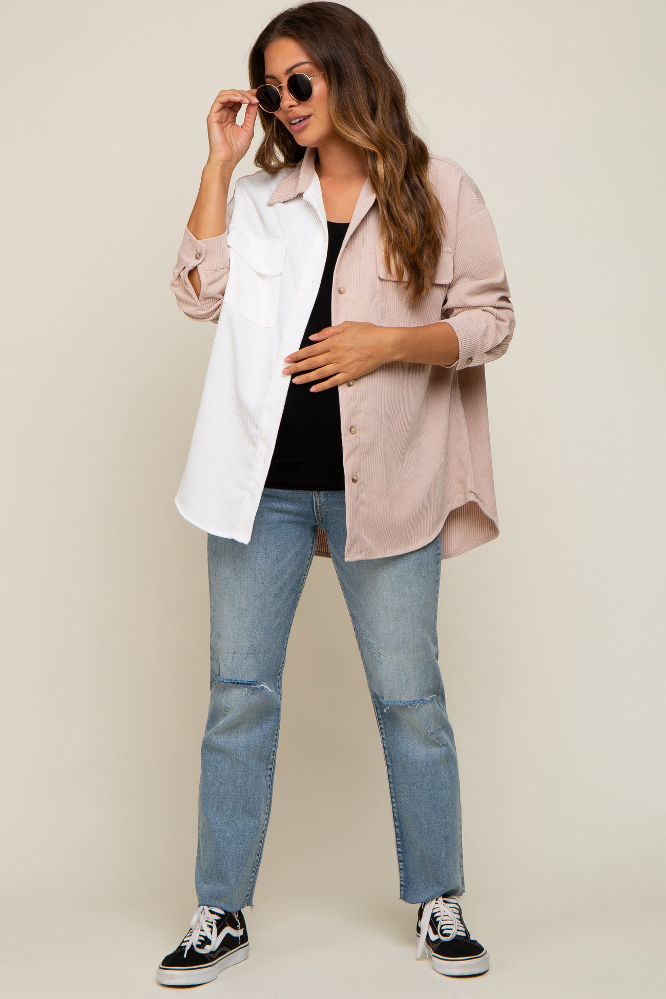 woman wearing a colorblock corduroy maternity shirt with distressed jeans and sunglasses