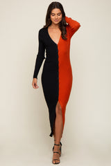 woman wearing a long sleeve two-tone black and orange ribbed knit button down midi dress with a leg slit