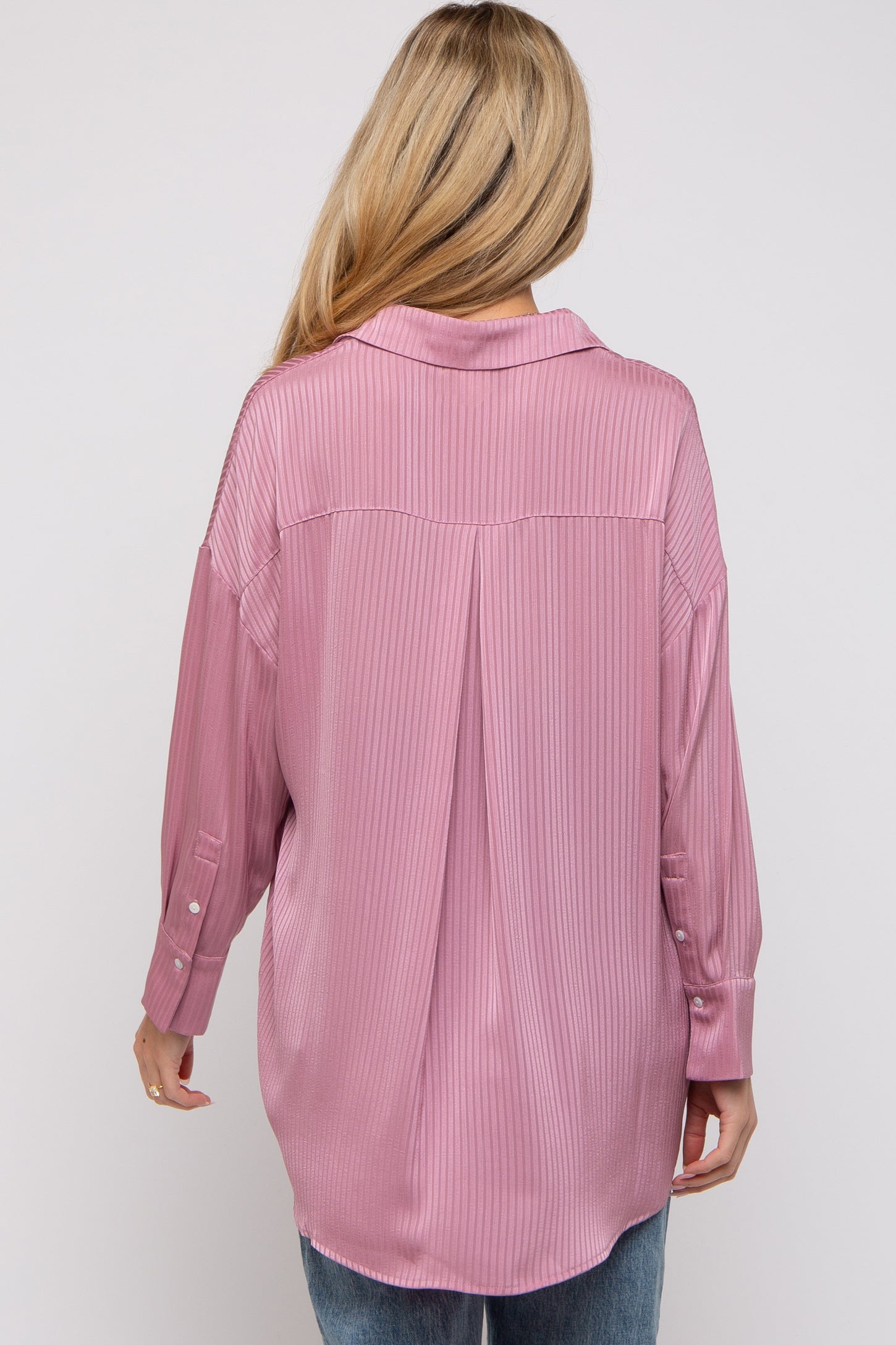 woman wearing a light pink striped maternity top, styled with long sleeves and a relaxed fit, showing the back view