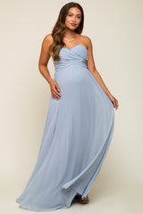 woman wearing a strapless light blue maternity gown with a ruched bodice and flowing skirt, showing her baby bump