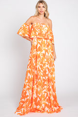 woman wearing an orange floral off-the-shoulder maxi dress with ruffled layers