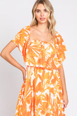 woman wearing a square neck orange floral print maxi dress with ruffled short sleeves