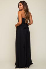 woman wearing a black strapless maternity gown with a flowing skirt and bow detail at the back