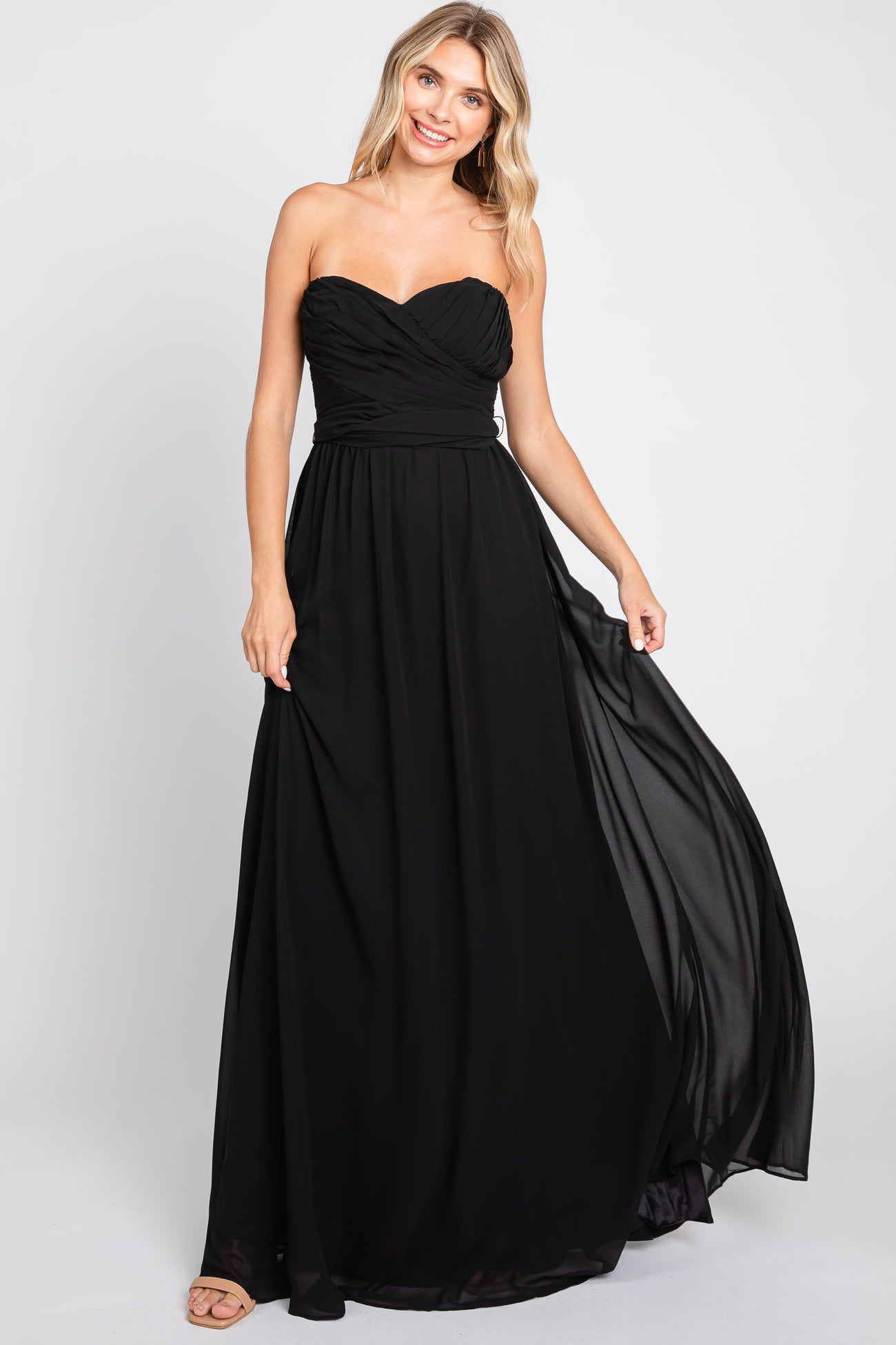 woman wearing a black strapless maxi dress with a sweetheart neckline and flowing skirt