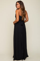 woman wearing a black strapless maternity gown with a bow detail and flowing skirt from the back