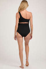 woman wearing a black one-shoulder maternity swimsuit with a cutout detail on the back