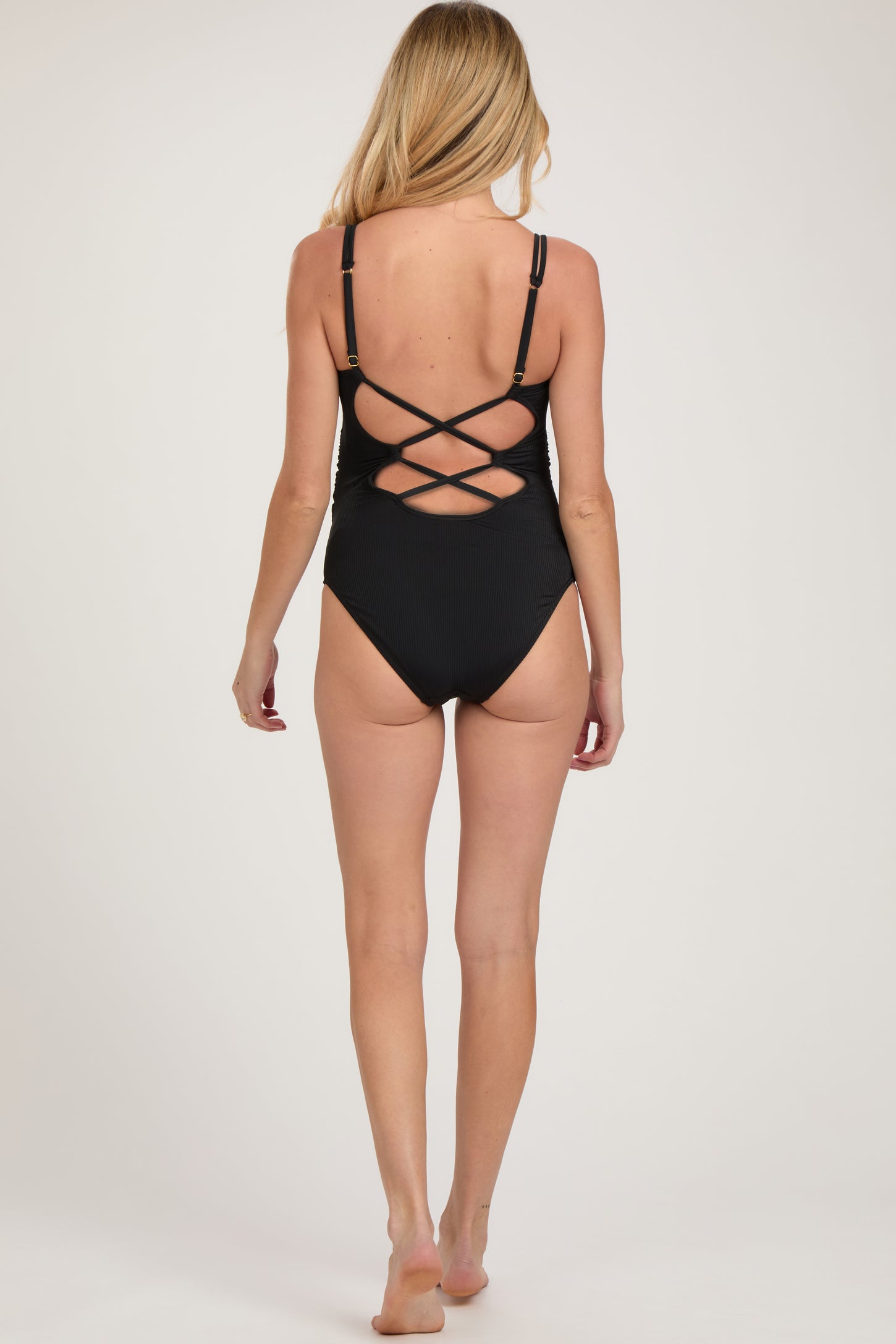 woman wearing a black maternity swimsuit with a crisscross back design