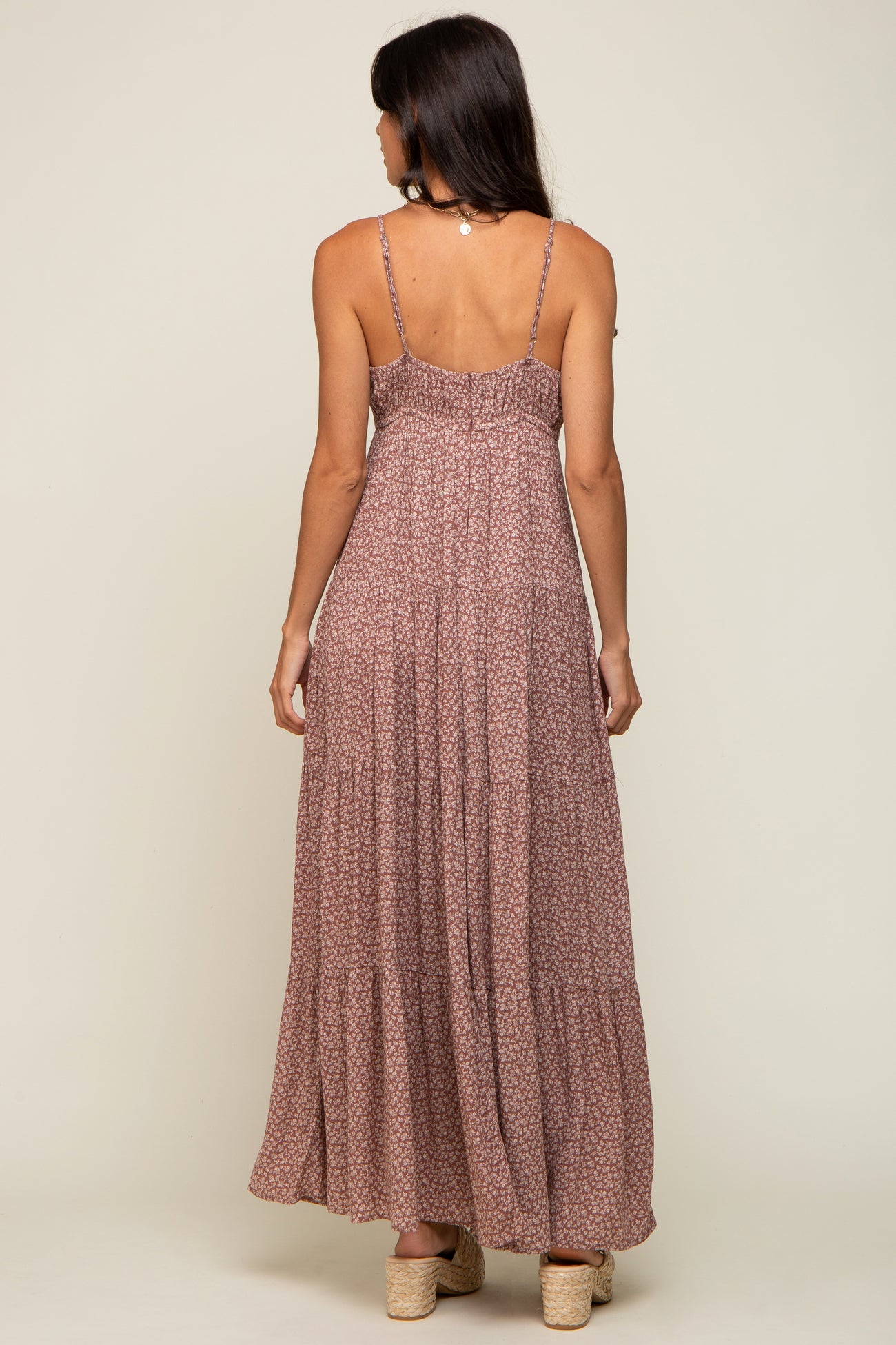 back view of woman wearing mauve floral tiered maxi dress with spaghetti straps and platform sandals
