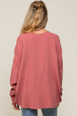 woman wearing a long sleeve dusty rose maternity top with a relaxed fit and frayed hem