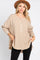 woman wearing a tan long sleeve gauze henley top with a brown wide brim hat and black jeans