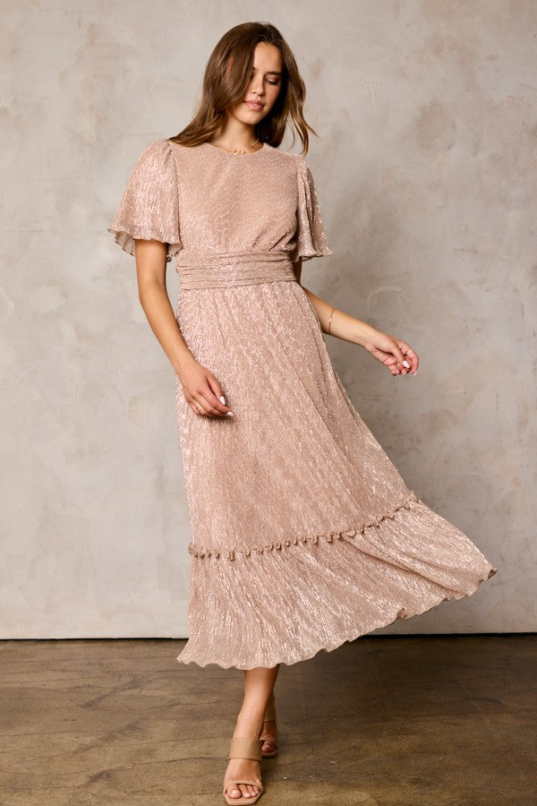 woman wearing a blush pink glittery maxi dress with flutter sleeves and ruffle hem detail