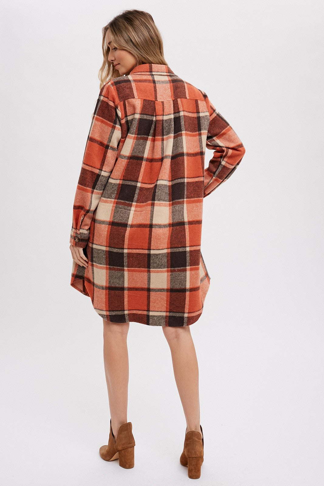 woman wearing a red and brown plaid oversized shirt dress with long sleeves and a button-up collar