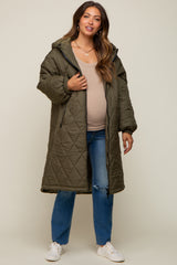 woman wearing an olive green long quilted maternity coat over a beige top, with a visible baby bump and blue jeans