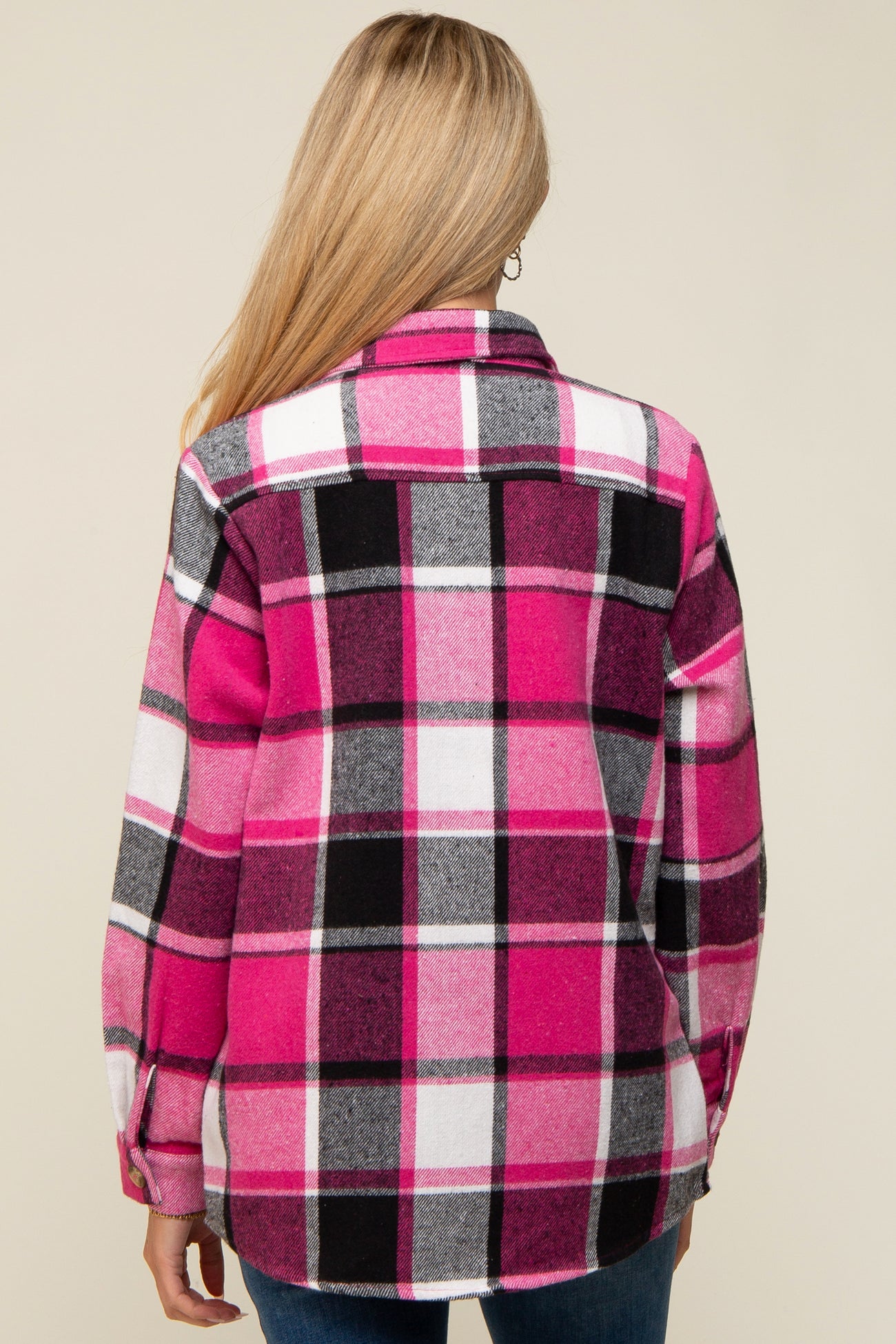 woman wearing a pink and black plaid maternity flannel shirt, showing the back view