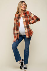 woman wearing a red and orange plaid maternity shacket over a white top, posing with her baby bump visible and paired with jeans and sneakers