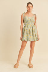 woman wearing a floral print mini dress with tie straps and woven platform sandals