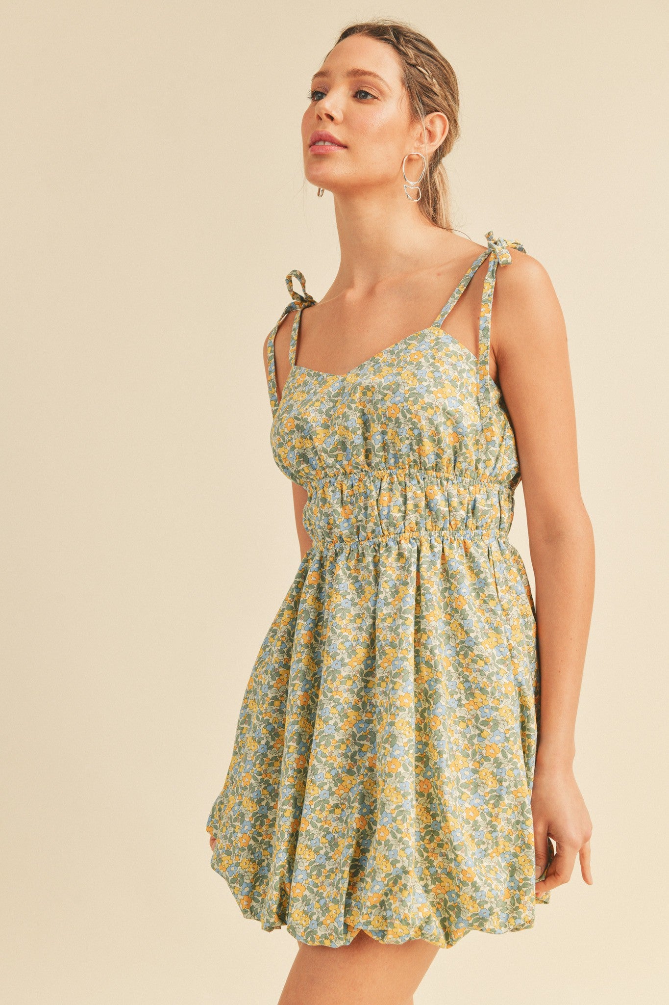 woman wearing a floral print sundress with tie straps and an elasticated waist