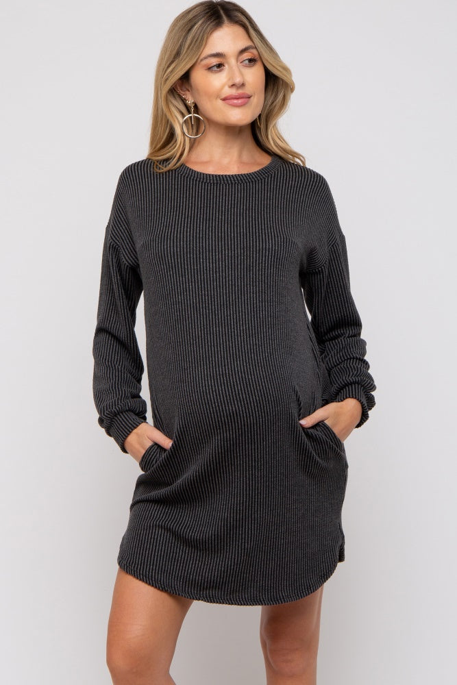 woman wearing a black striped long sleeve maternity dress with pockets and a visible baby bump