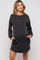 woman wearing a black striped long sleeve maternity dress with pockets and a visible baby bump