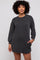 woman wearing a loose-fitting black and gray striped long sleeve sweater dress with side pockets