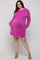 woman wearing a hot pink ribbed maternity dress with long sleeves and pockets, showcasing her baby bump